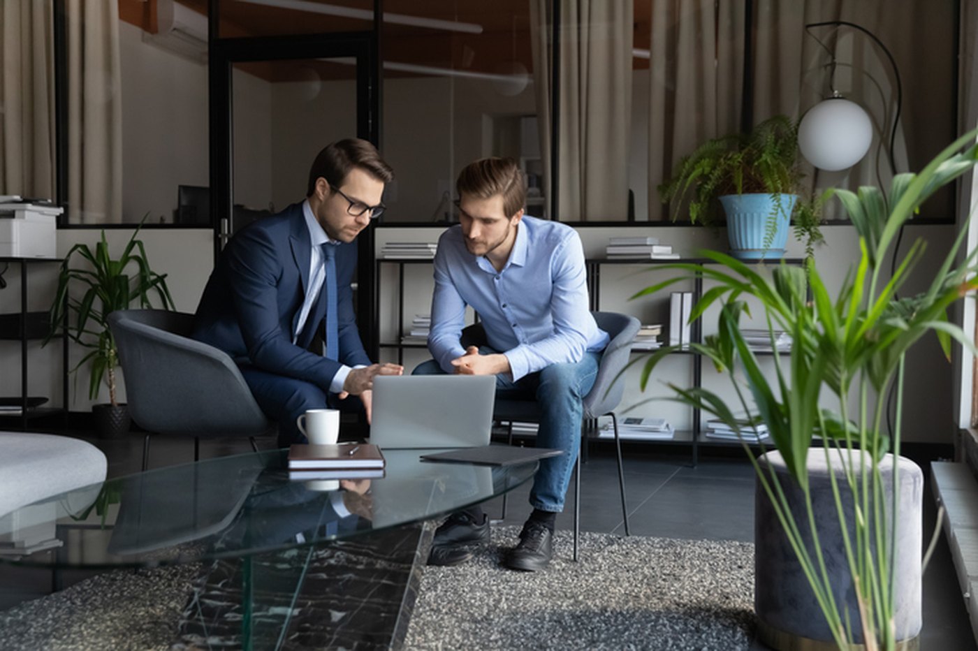 An advisor and a practice owner reviewing options together on a laptop