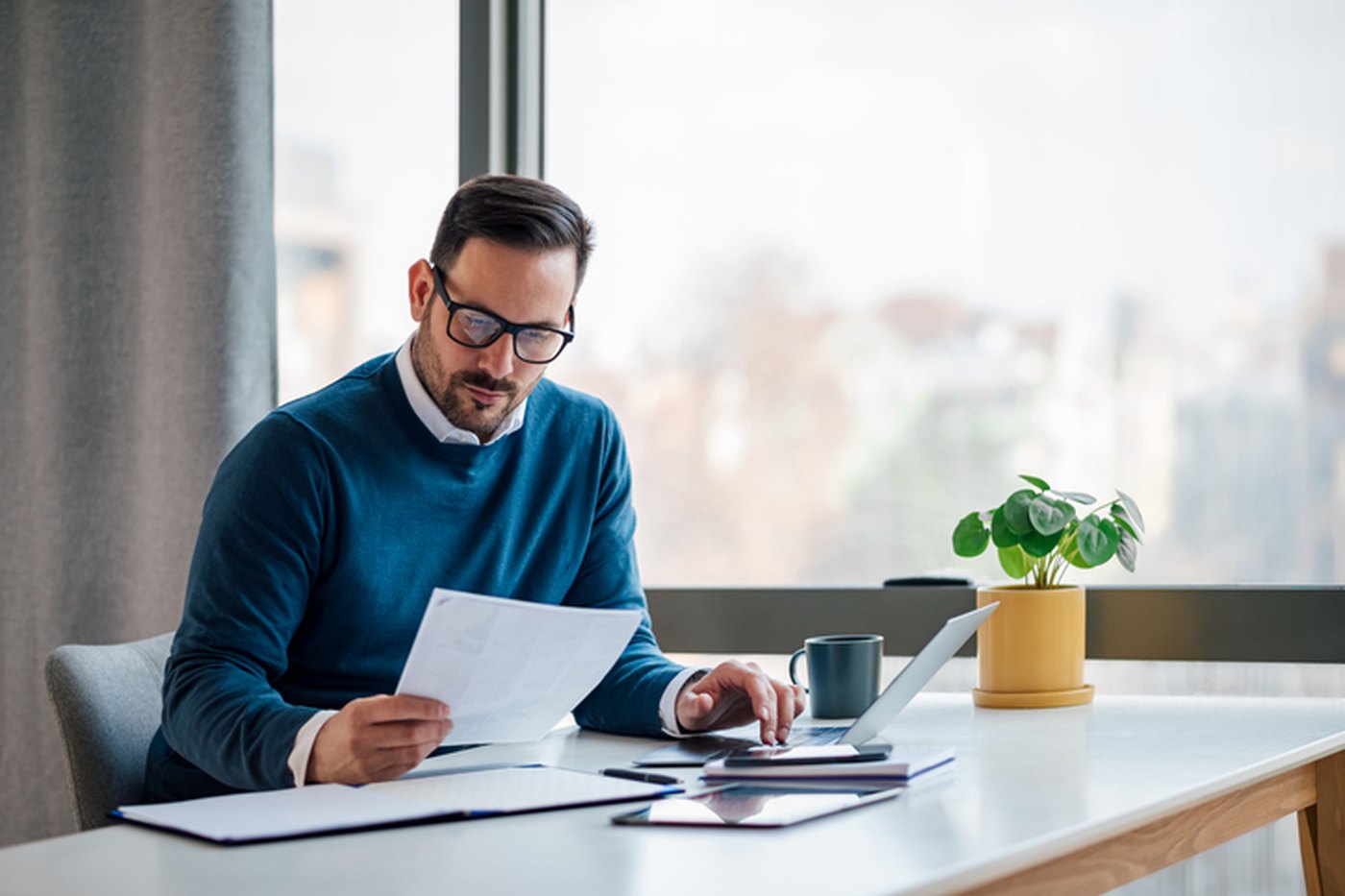 A fractional CFO reviewing financial statements at a desk overlooking the city
